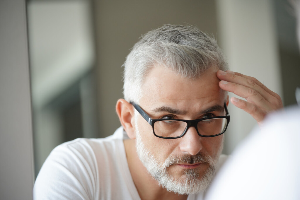 Homem analisando os resultados do tratamento de crescimento capilar