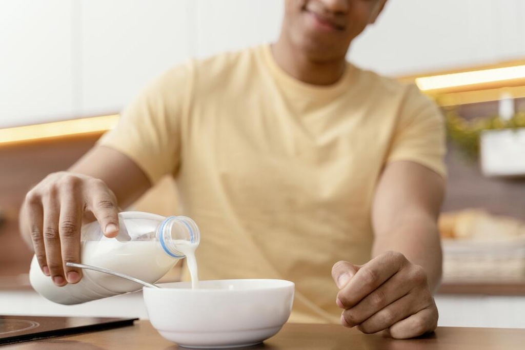 Homem tomando leite sem lactose porque tem intolerância a lactose