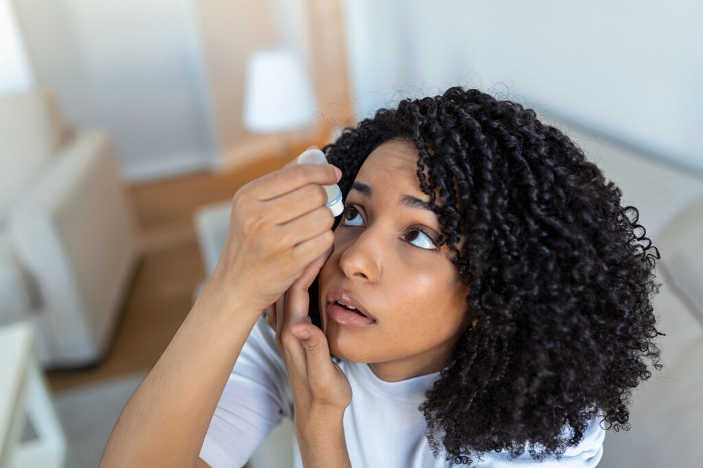 Mulher usando colírio e pensando se usar colírio todos os dias faz mal